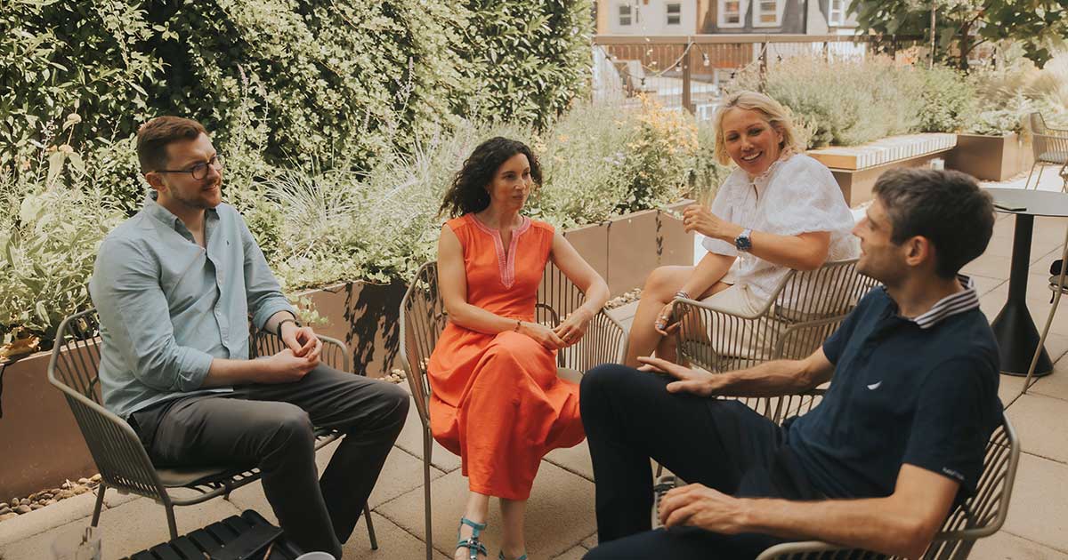 Small group of Forsters lawyers sitting on a roof terrace surrounded by greenery